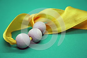 Wooden beads and yellow ribbon on a green background