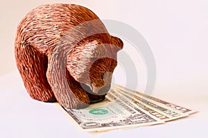 Wooden bear on dollars