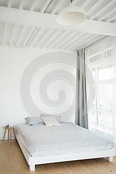 A wooden bed near the window. Hugge. Furniture.