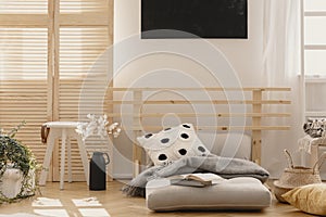 wooden bed with scandinavian futon with pillow and blanket, real photo with copy space and mockup