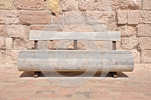 Wooden bench against a stone wall