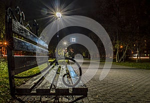 A wooden bench in the alley at night