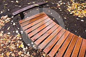 Wooden bench in autumn park after rain. Place of breath of townspeople
