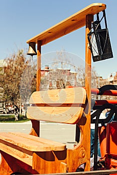 A wooden bench with a bell and a lantern on a red fire truck