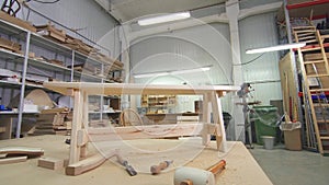 A wooden bench in a carpenter`s workshop, among chips and tools