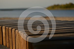 Wooden bench close-up against the background of the river