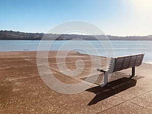 Wooden bench on coast at the beach.