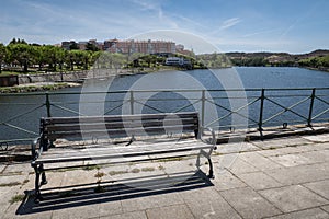 The wooden bench facing the river photo