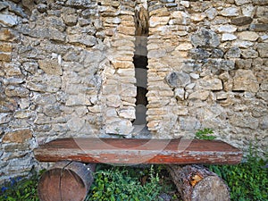 Dřevěná lavice před trhlinou v kamenné zdi u zříceniny hradu Čachtice na Slovensku