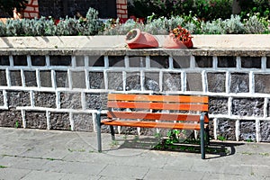 Wooden bench in front of a stone wall
