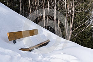 Wooden bench on a hill covered with snow