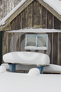 wooden bench at the house under the snow in winter
