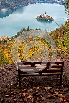 Wooden bench over the alpine lake Bled Blejsko jezero with fantastic view, outdoor travel background, Slovenia