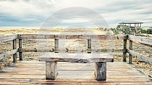 A wooden bench overlooking the sand dunes of the Curonian Lagoon and the Curonian Bay