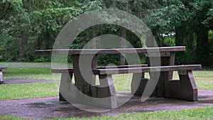 wooden bench in the park with a desk, for a picnic and relaxation in the forest area