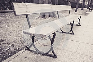 Wooden bench in park, pavement - sepia photograph