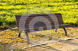 Wooden bench in a park at sunset