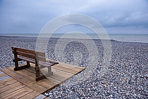 Wooden bench at a pebbles beach