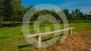 Wooden bench in a recreation area on the river bank