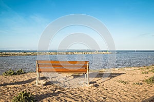 Wooden bench for resting with views of the mouth of the Segura river at sunset. Alicante, Spain