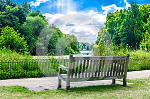A wooden bench at St James`s Park in the summer