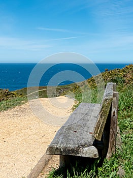 Wooden bench standing on the hiking trail near Luanco, Asturias,Spain