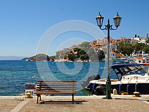 Wooden bench and street lamp on the promenade in Skiathos, Greece