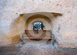 Wooden bench and window in ancient stone wall, Salzburg