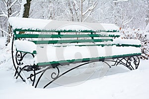 Wooden bench in the winter park covered snow