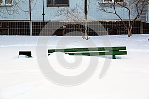 Wooden bench in winter under the snow, inaction of snow blowers in the snowfall