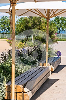 Wooden benchen with parasols in a public park