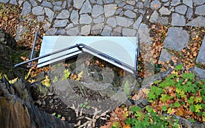 Wooden benches of irregular geometric polygons on stone gray pavement in a park with low retaining walls stacked of porphyry. orna