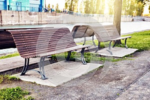 Wooden benches in a park near the riverside at sunset