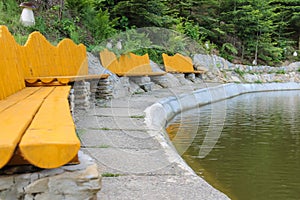 Wooden benches on shore of lake in Ukrainian Carpathian