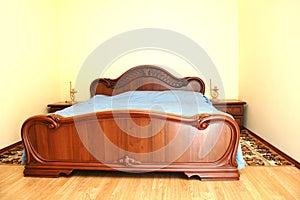 Wooden big bed in bedroom