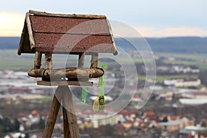 Wooden bird feeder on city background