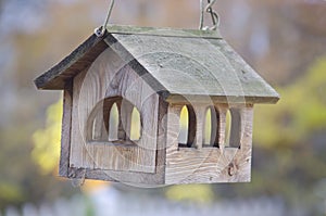 Wooden bird feeder in the form of a house.