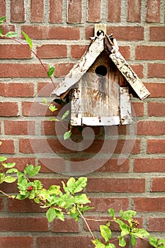 Wooden birdhouse on brick wall