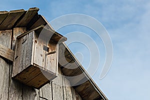 Wooden birdhouse on a wooden barn wall