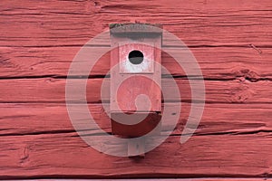 Wooden birdhouse on a wooden house facade