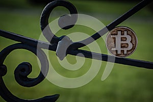 Wooden Bit Coin on steel rusty old fence in a sun