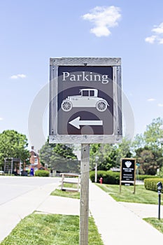 A wooden black and white outdoor parking sign