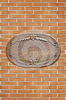 Wooden blank sign with floral decorations against a brick wall - image with copy space