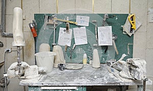 Wooden blanks, Bench Vices, pots and tools placed on a work table for manufacturing artificial limbs