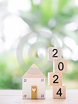 Wooden block with 2024 and miniature house. The concept of Property investment, House mortgage, Real estste