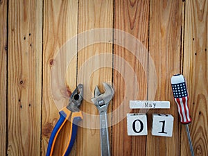 Wooden block calendar 1 May and Joinery tools on a wooden table