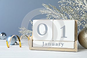 Wooden block calendar and Christmas decor on table. New Year celebration