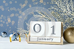 Wooden block calendar and Christmas decor on white table. New Year celebration