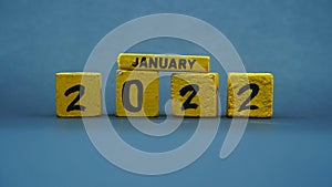 Wooden block calendar for January 2022. Yellow on a dark background