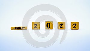 Wooden block calendar for January 2022. Yellow on a white background